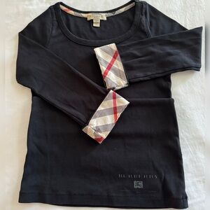 Burberry long sleeve top in classic black with signature plaid cuff details.